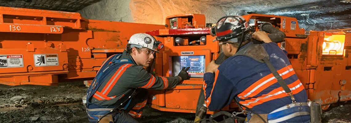 Mine personnel reviewing technology on Joy underground mining equipment